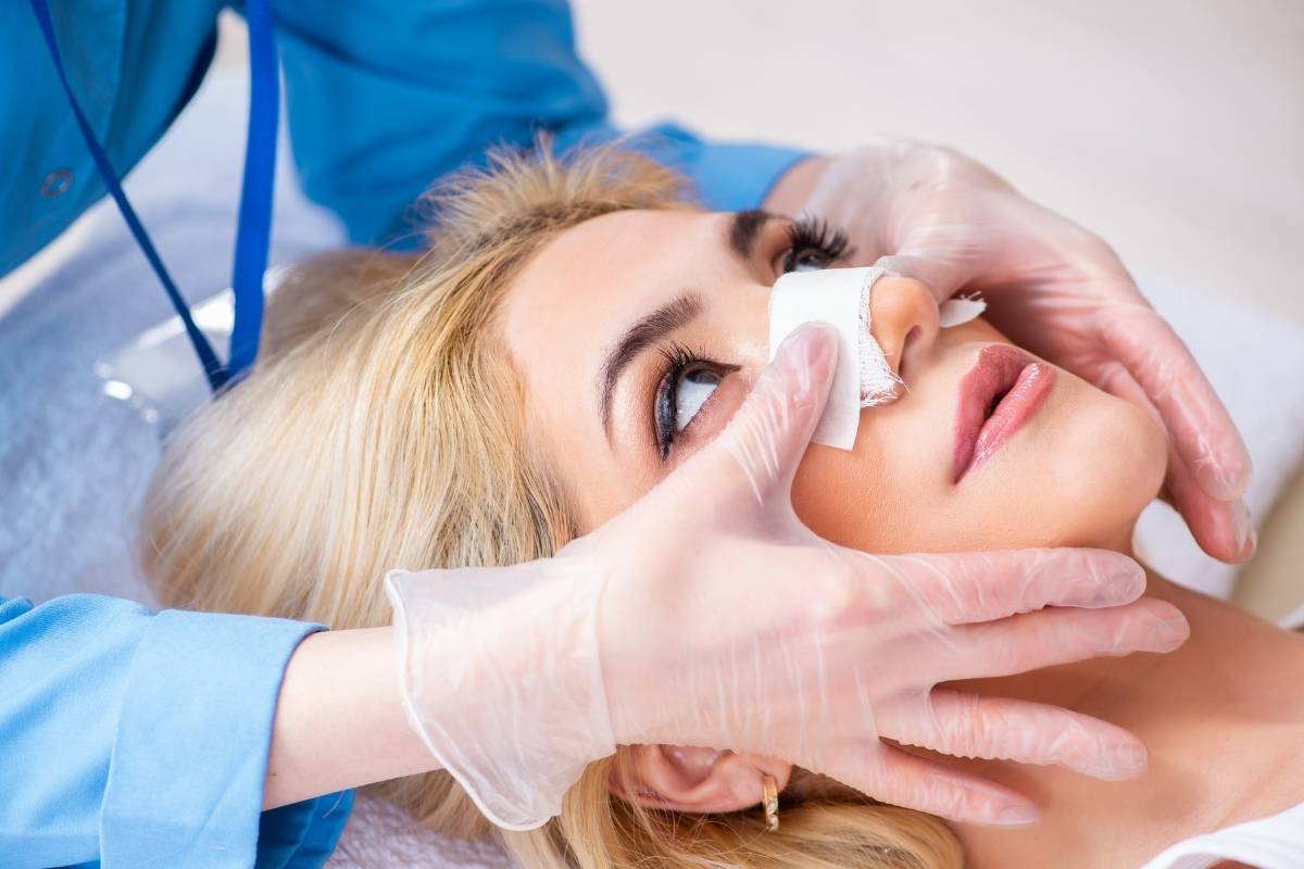 A surgeon performing a nose job to reshape the nasal structure for better aesthetics.