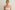 Post-pregnancy woman with flat abdomen and lifted breasts after mommy makeover surgery.