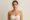 Post-pregnancy woman with flat abdomen and lifted breasts after mommy makeover surgery.